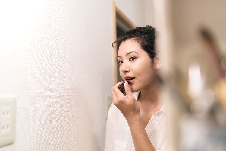Image of a woman in her thirties applying makeup