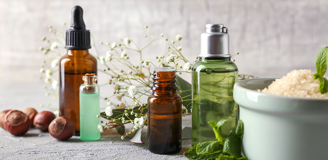 Des soins de beauté sont posés sur une table, entourés d'ingrédients naturels utilisés en cosmétique. 