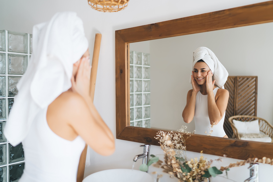 Une personne applique sa crème pour le visage contenant de la vitamine E et de la vitamine C.