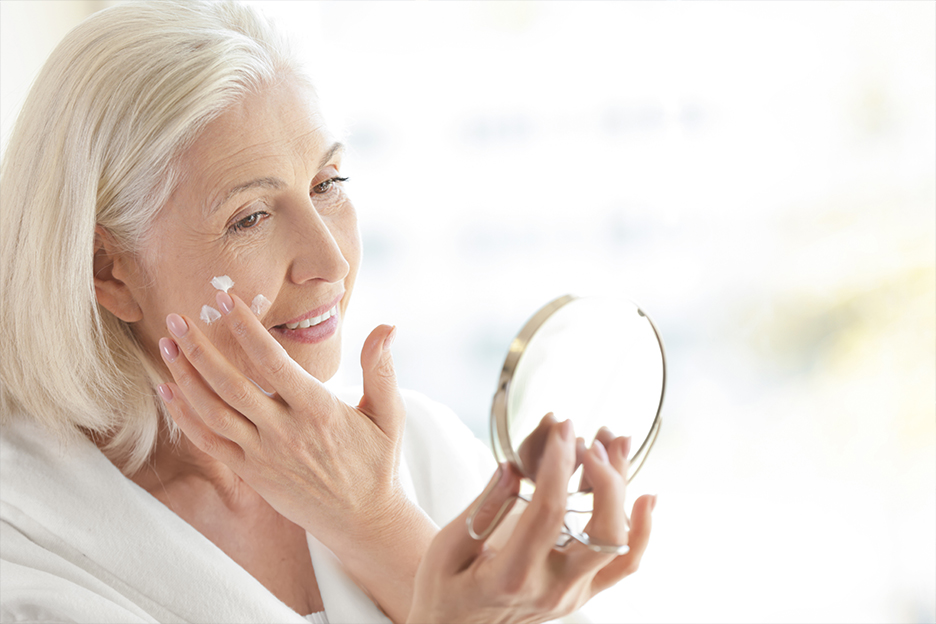 Femme appliquant de la crème sur son visage.