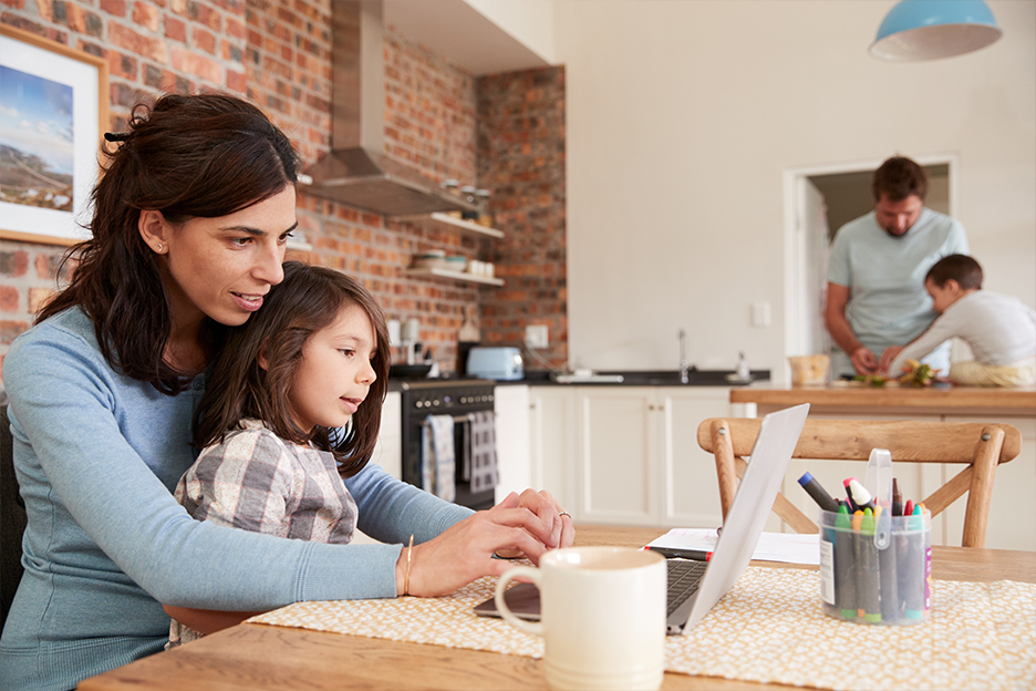 Une femme et un homme s'occupent de leurs enfants dans la cuisine et ressentent la charge mentale d'être parents.