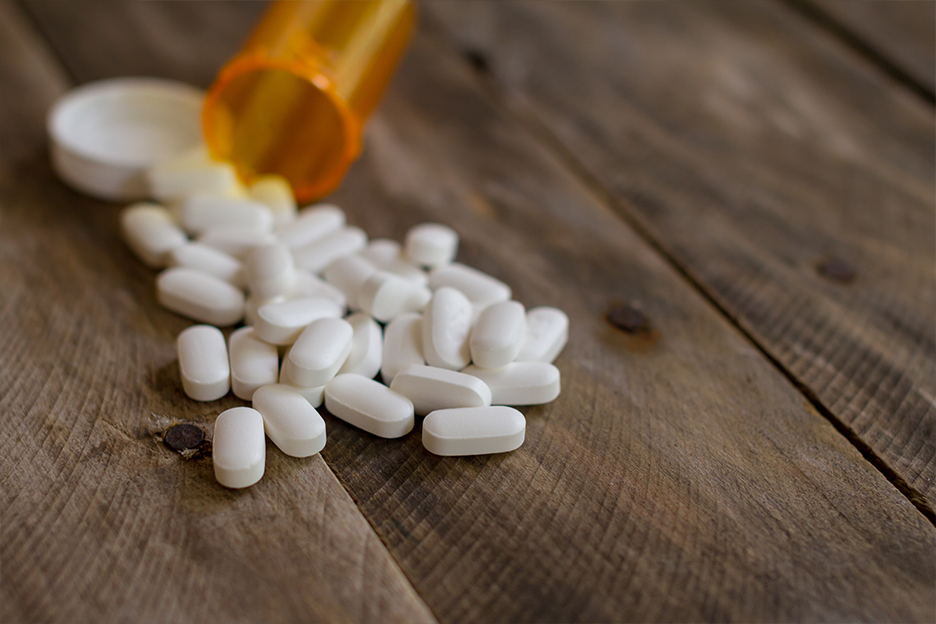 Un flacon d'opioïdes renversé sur une table.