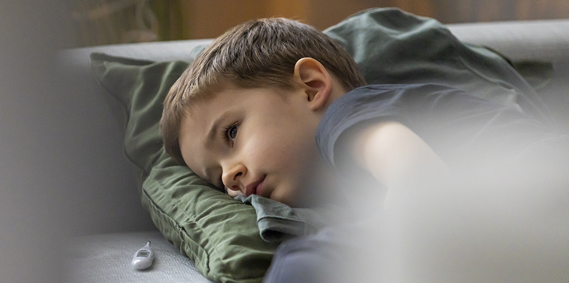 An educator and three children play at daycare, an environment conducive to gastroenteritis in children.