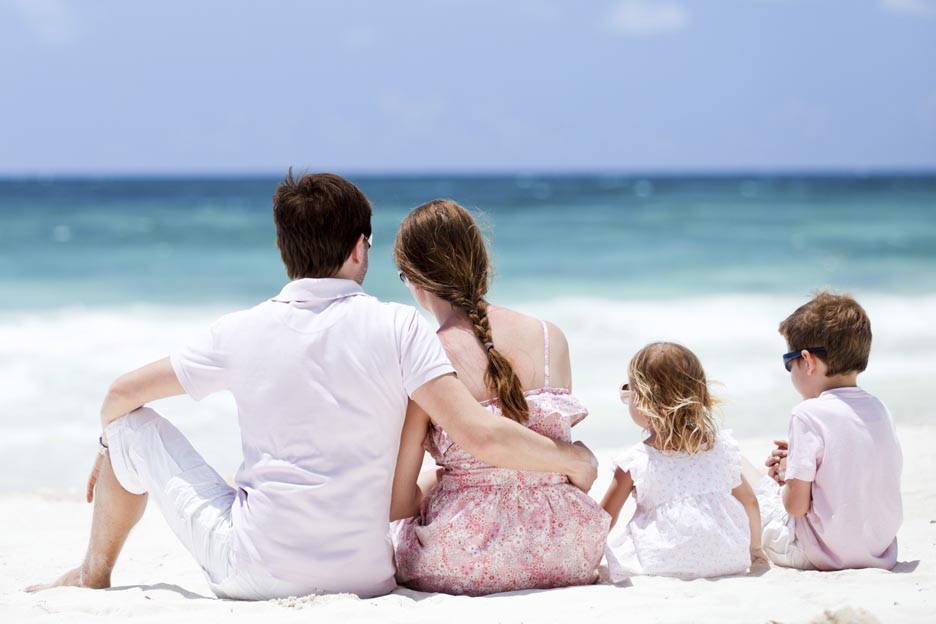 A young family on a trip is relaxing on a beach. 