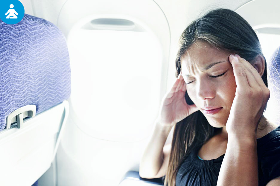 A woman with motion sickness experiences headaches while on a plane.