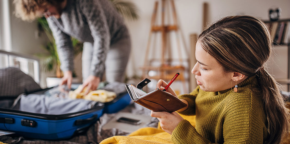 Couple qui prépare ses bagages et fait sa liste de la trousse de soins
